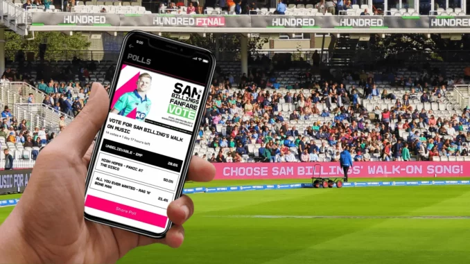 Fan dans un stade regardant son smartphone pendant une rencontre sportive, illustrant une activation en temps réel dans le sport.