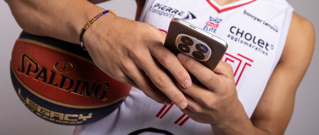 Joueur de Cholet tenant un smartphone Xiaomi lors du partenariat avec la LNB