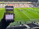 Supporter utilisant son smartphone pendant un match de football illustrant les micro-contenus