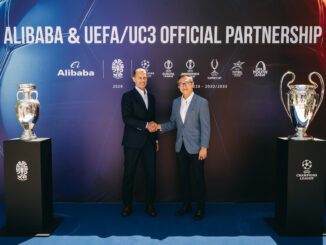 Alibaba UEFA partenariat officiel : Aleksander Čeferin (président de l'UEFA) et Joe Tsai (président d'Alibaba Group) se serrent la main lors de la cérémonie de lancement à Budapest, entourés du trophée Henri Delaunay (EURO 2028) et de la coupe aux grandes oreilles (UEFA Champions League)