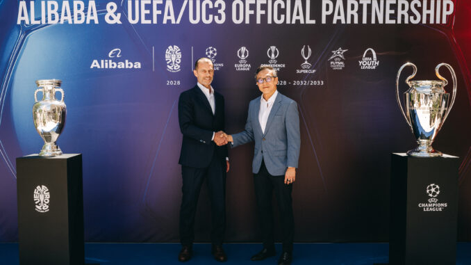 Alibaba UEFA partenariat officiel : Aleksander Čeferin (président de l'UEFA) et Joe Tsai (président d'Alibaba Group) se serrent la main lors de la cérémonie de lancement à Budapest, entourés du trophée Henri Delaunay (EURO 2028) et de la coupe aux grandes oreilles (UEFA Champions League)