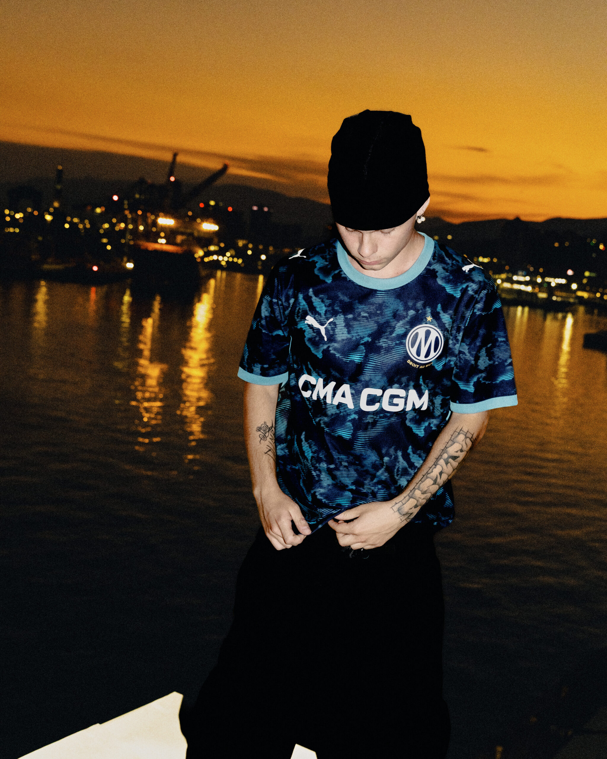 Coucher de soleil sur le port de Gênes avec le nouveau maillot extérieur de l'Olympique de Marseille. Photo d'Andrea Venturini. Crédit : PUMA × Olympique de Marseille