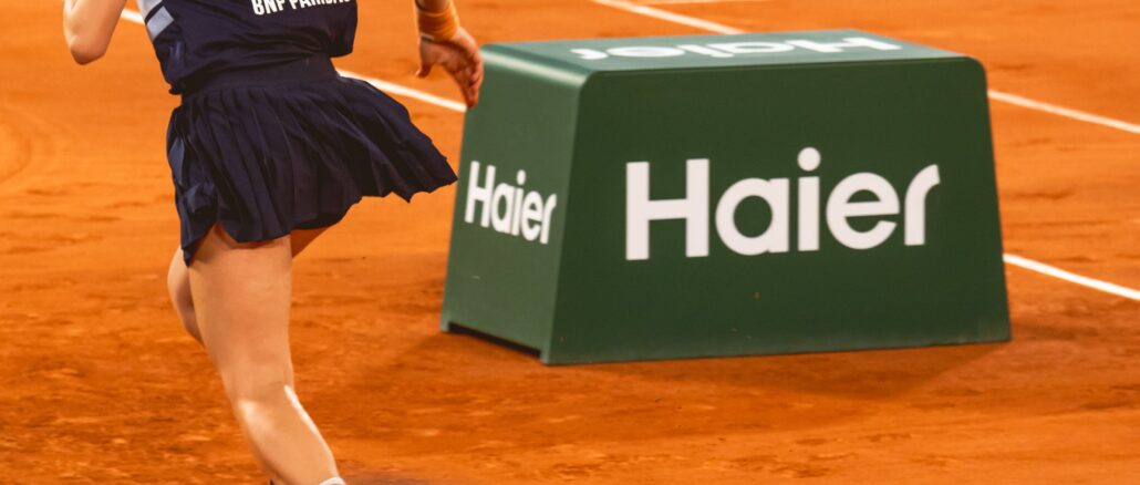 Ramasseuse de balles devant une Netbox Haier sur le court de Roland-Garros 2026