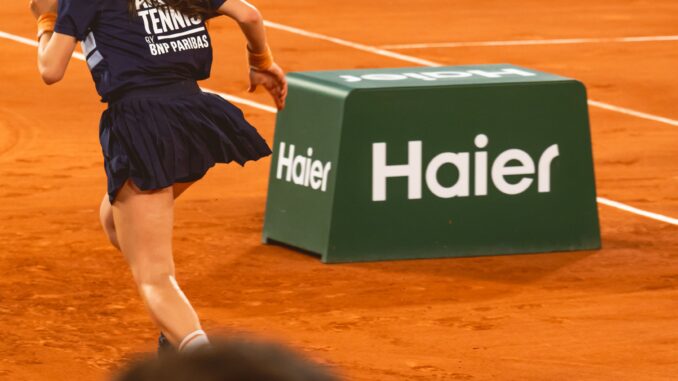 Ramasseuse de balles devant une Netbox Haier sur le court de Roland-Garros 2026