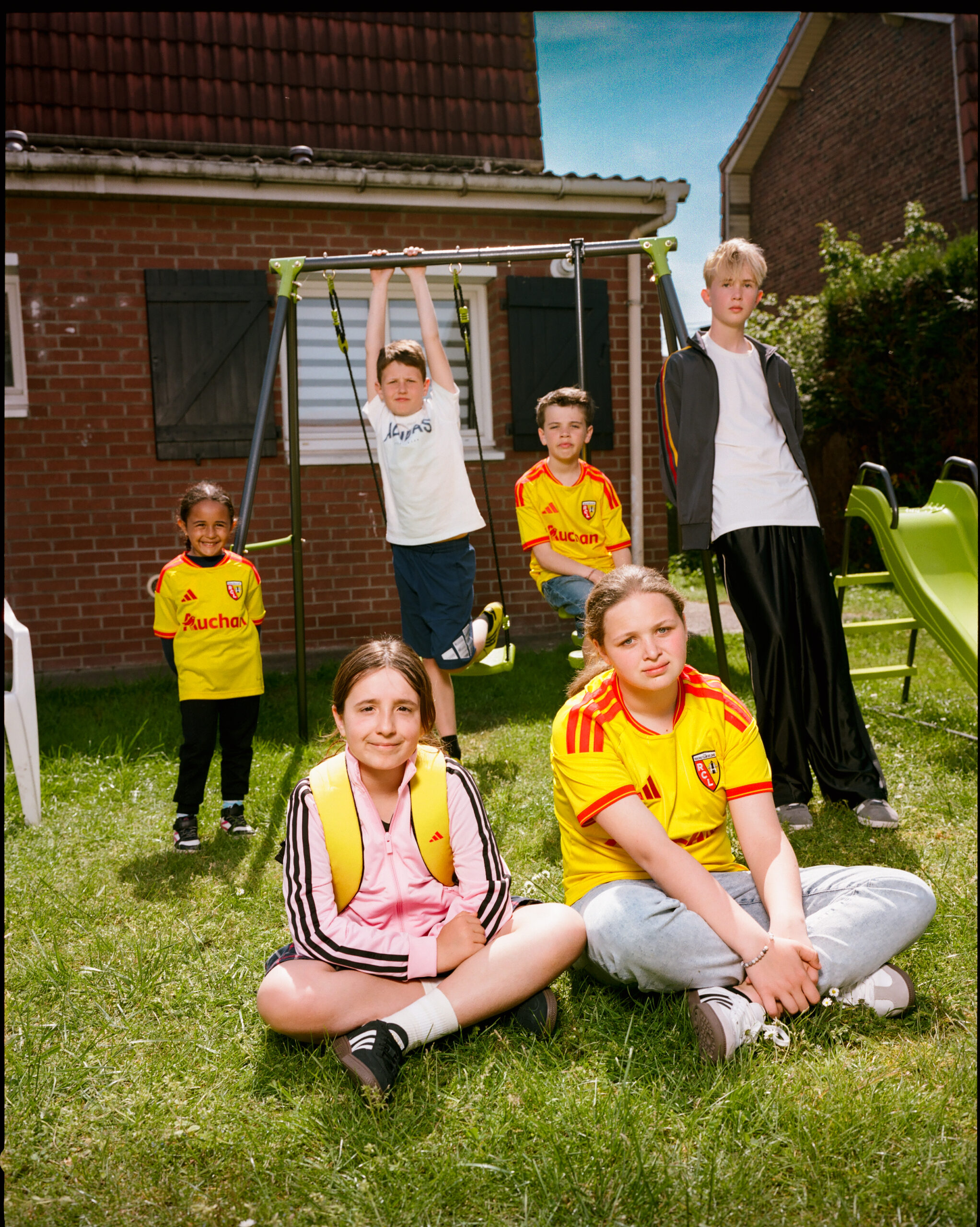 Enfants portant le maillot adidas RC Lens 2026-2027 dans un jardin du Pas-de-Calais