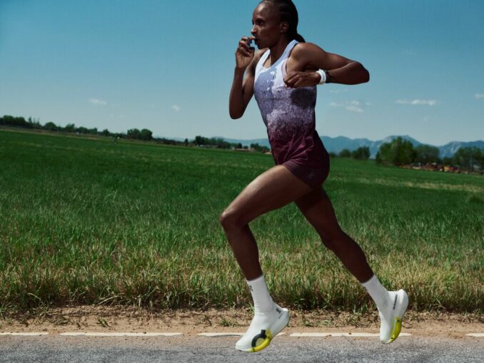 Hellen Obiri en pleine foulée, poings serrés près du visage, portant la On Cloudboom Strike 2, campagne Race for the Feeling