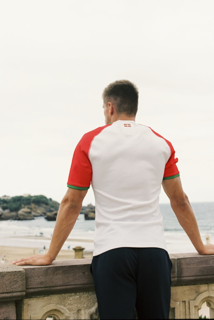Dos du maillot domicile 2026-2027 du Biarritz Olympique avec le drapeau basque, face à la Grande Plage de Biarritz