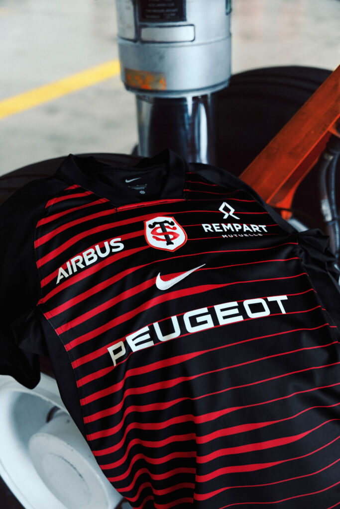Détail de la face avant du maillot domicile 2026-2027 du Stade Toulousain avec les logos Airbus, Peugeot, Rempart Mutuelle et Nike