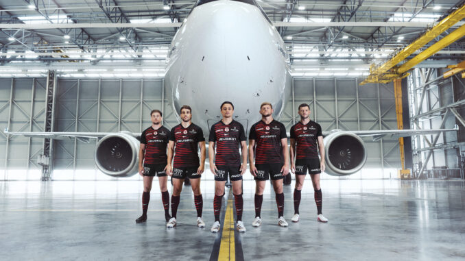 Joueurs du Stade Toulousain en maillot domicile 2026-2027 devant un A330neo dans les installations d'Airbus