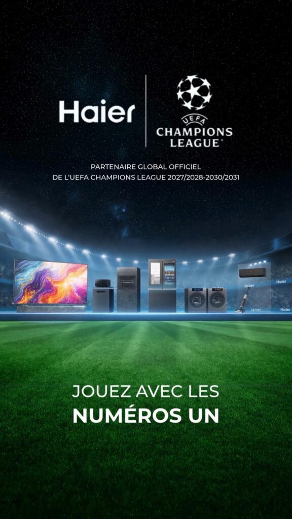 Visuel de campagne Haier « Jouez avec les numéros un » — gamme d'électroménager et téléviseur alignés sur une pelouse de stade sous les logos Haier et UEFA Champions League