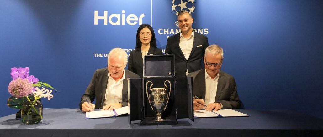 Signature du partenariat entre Haier et l'UEFA Champions League devant le trophée de la Ligue des champions