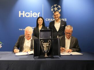 Signature du partenariat entre Haier et l'UEFA Champions League devant le trophée de la Ligue des champions