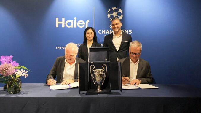 Signature du partenariat entre Haier et l'UEFA Champions League devant le trophée de la Ligue des champions