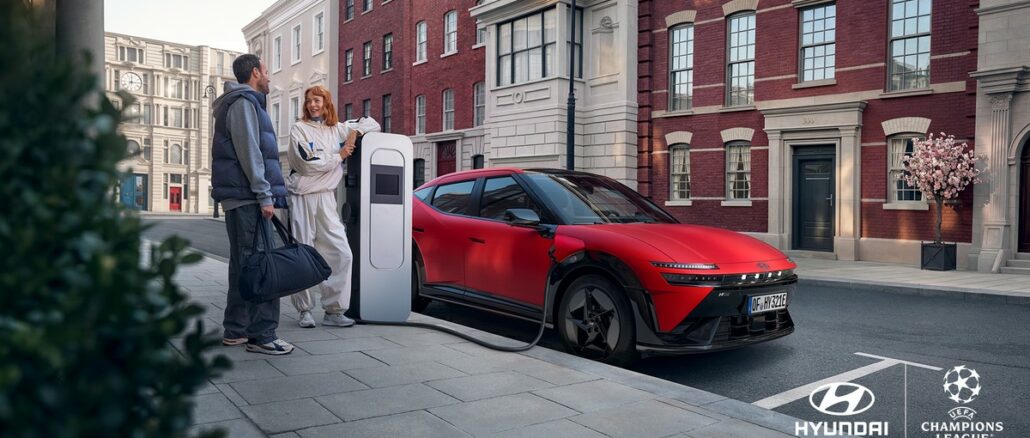 Visuel de campagne Hyundai et UEFA Champions League : la Hyundai IONIQ 3 N Line rouge en recharge dans une rue, avec les logos des deux partenaires