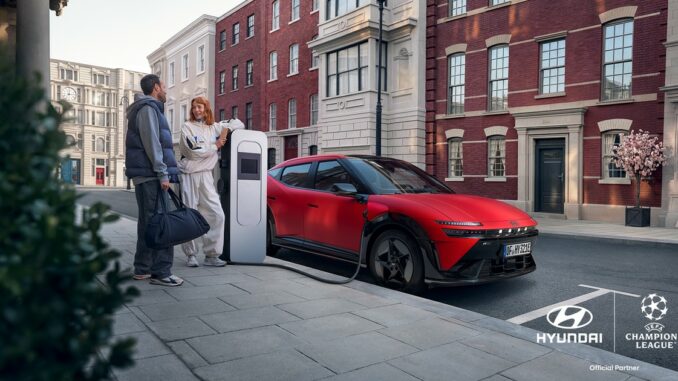 Visuel de campagne Hyundai et UEFA Champions League : la Hyundai IONIQ 3 N Line rouge en recharge dans une rue, avec les logos des deux partenaires