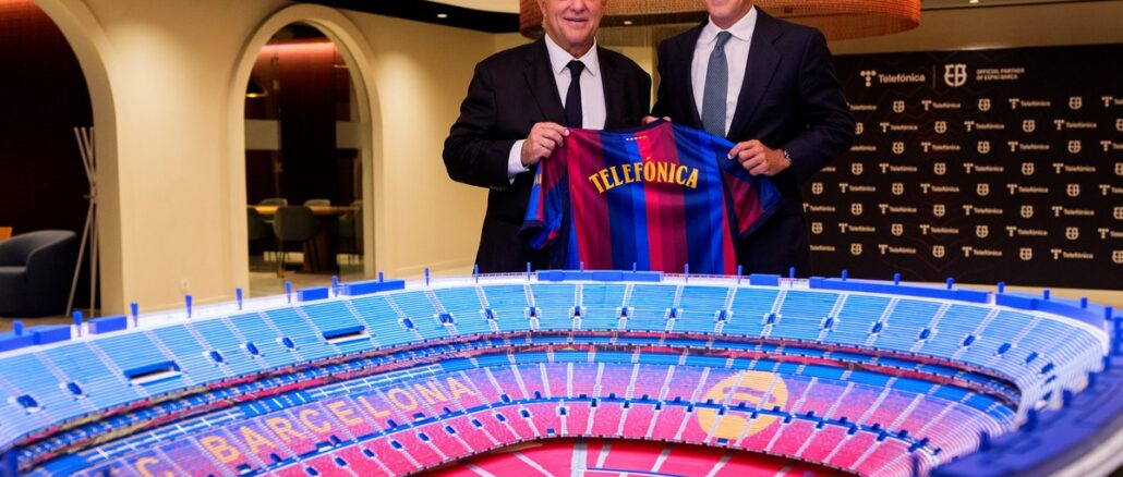 Joan Laporta et Borja Ochoa tiennent un maillot Telefónica derrière la maquette du futur Spotify Camp Nou