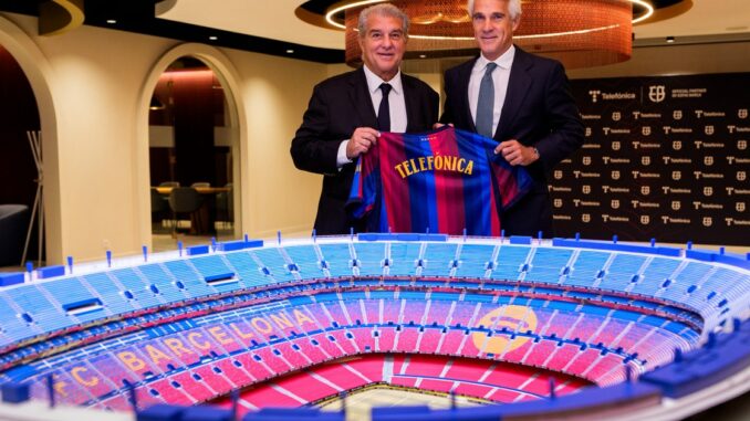 Joan Laporta et Borja Ochoa tiennent un maillot Telefónica derrière la maquette du futur Spotify Camp Nou