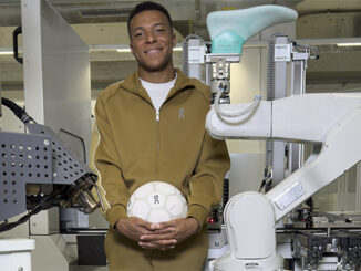 Kylian Mbappé tient un ballon On devant un bras robotisé au On Labs Zurich