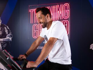 Nenê, légende du PSG, sur un vélo d'appartement dans l'espace fitness Training Ground d'un hôtel Novotel