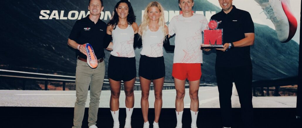 Athlètes et dirigeants sur scène devant le logo Salomon IRONMAN lors de l'annonce du partenariat