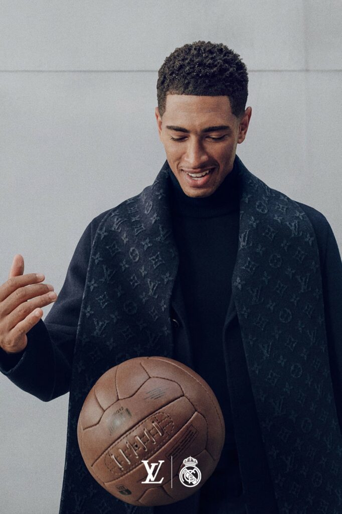 Joueur du Real Madrid en manteau noir en cachemire et écharpe Monogram Louis Vuitton, un ballon à la main
