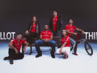 Joueurs du Stade Toulousain et jeunes Toulousains posant autour d'un banc public avec le maillot third rouge 2026-2027