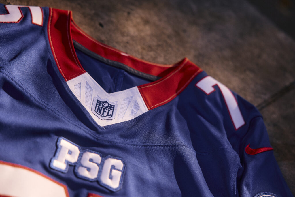 Col du maillot PSG × NFL Red & Blue avec l’écusson de la NFL, l’inscription PSG et le swoosh Nike