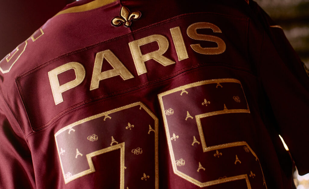 Dos du maillot Monogramme PSG × NFL grenat et or, numéro 75 orné de fleurs de lys et de tours Eiffel