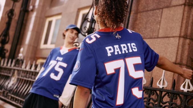 Deux jeunes portant le maillot de football américain PSG × NFL Paris Red & Blue, floqué PARIS 75, dans une rue parisienne