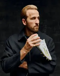 Harry Kane tenant la paire de chaussures de football Skechers SKX_2 blanc et or créée pour son Ballon d'Or 2026